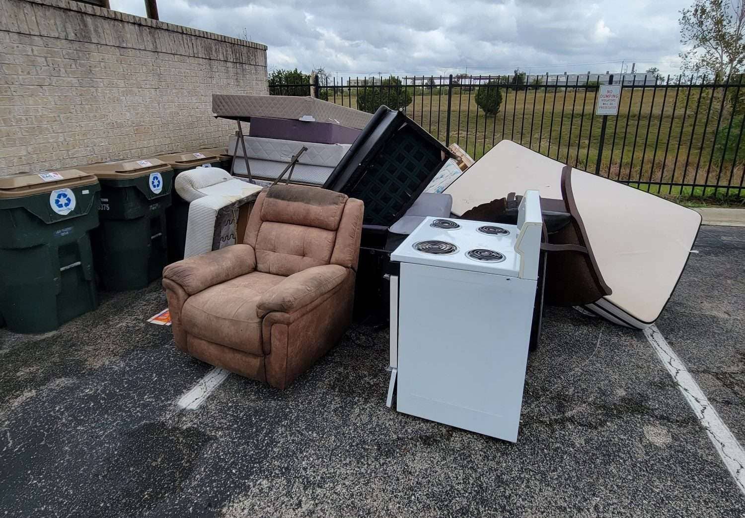 bulk junk couch recliner appliance by dumpster that needs removal in Buda